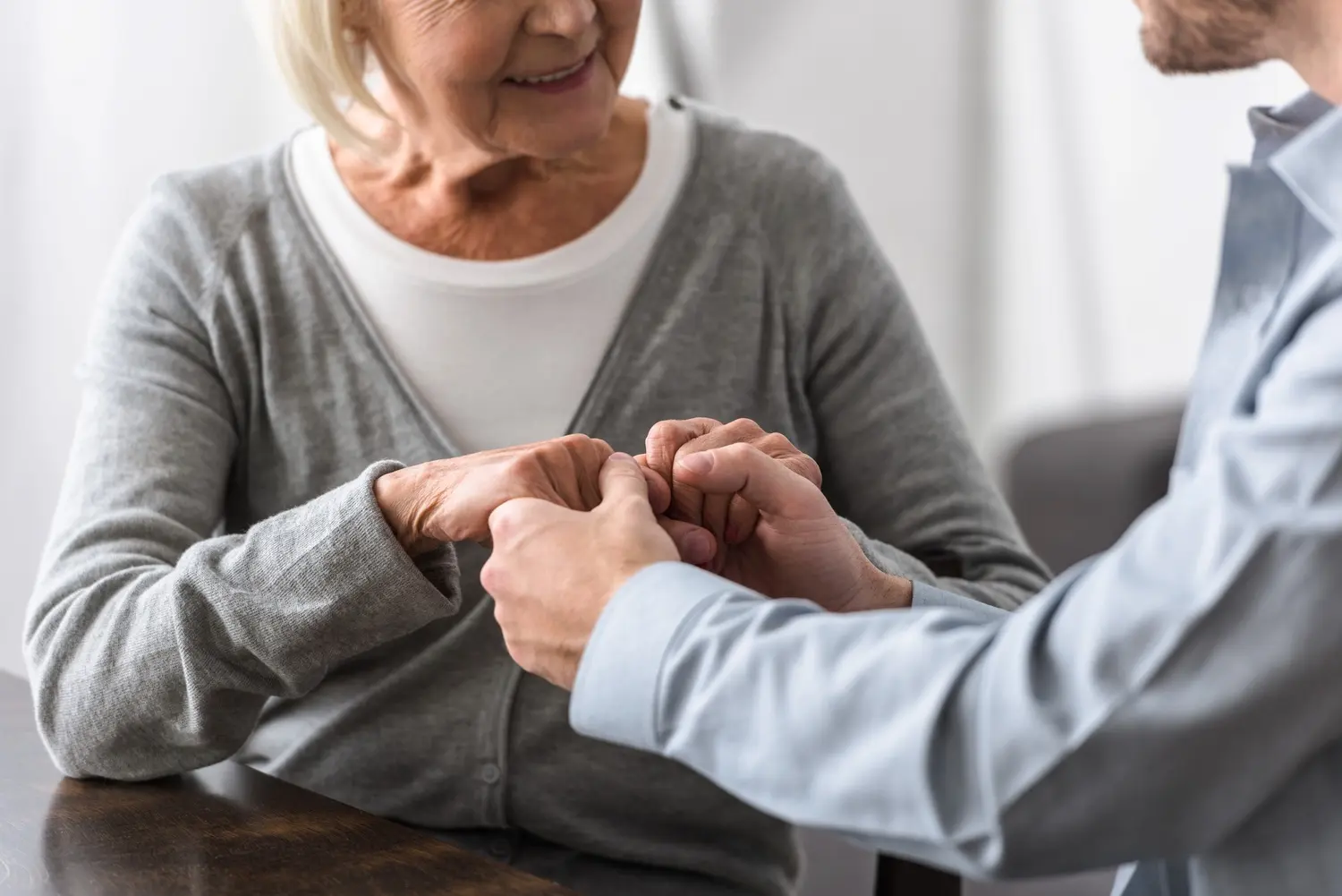 cropped view of smiling senior woman holding hands utc